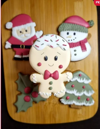 Biscoito decorado de bonequinho de Natal com outros modelos ao fundo.